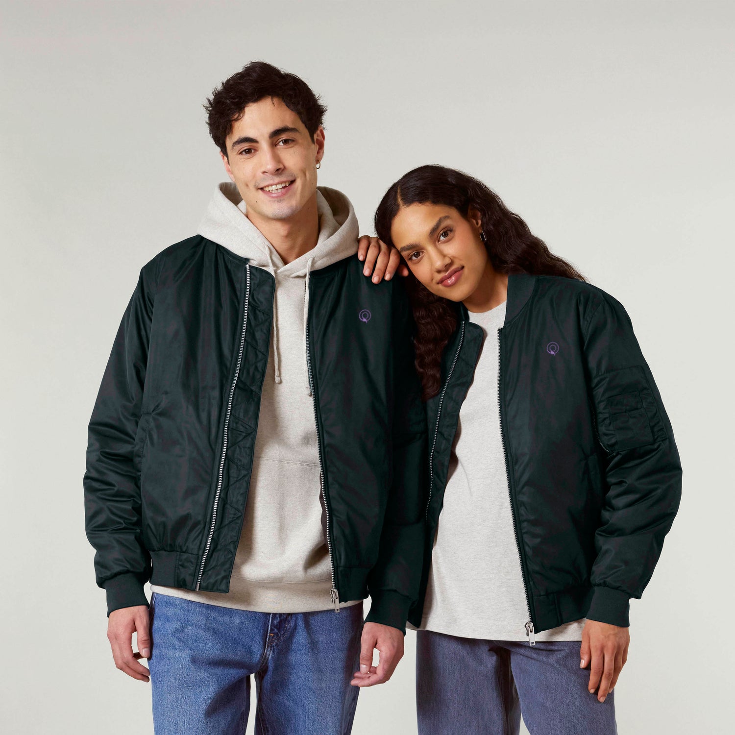 Two models wearing navy blue NEW WORLD GUARDIANS vegan bomber jackets made from recycled polyester, eco-friendly unisex fashion essential, 3 colors