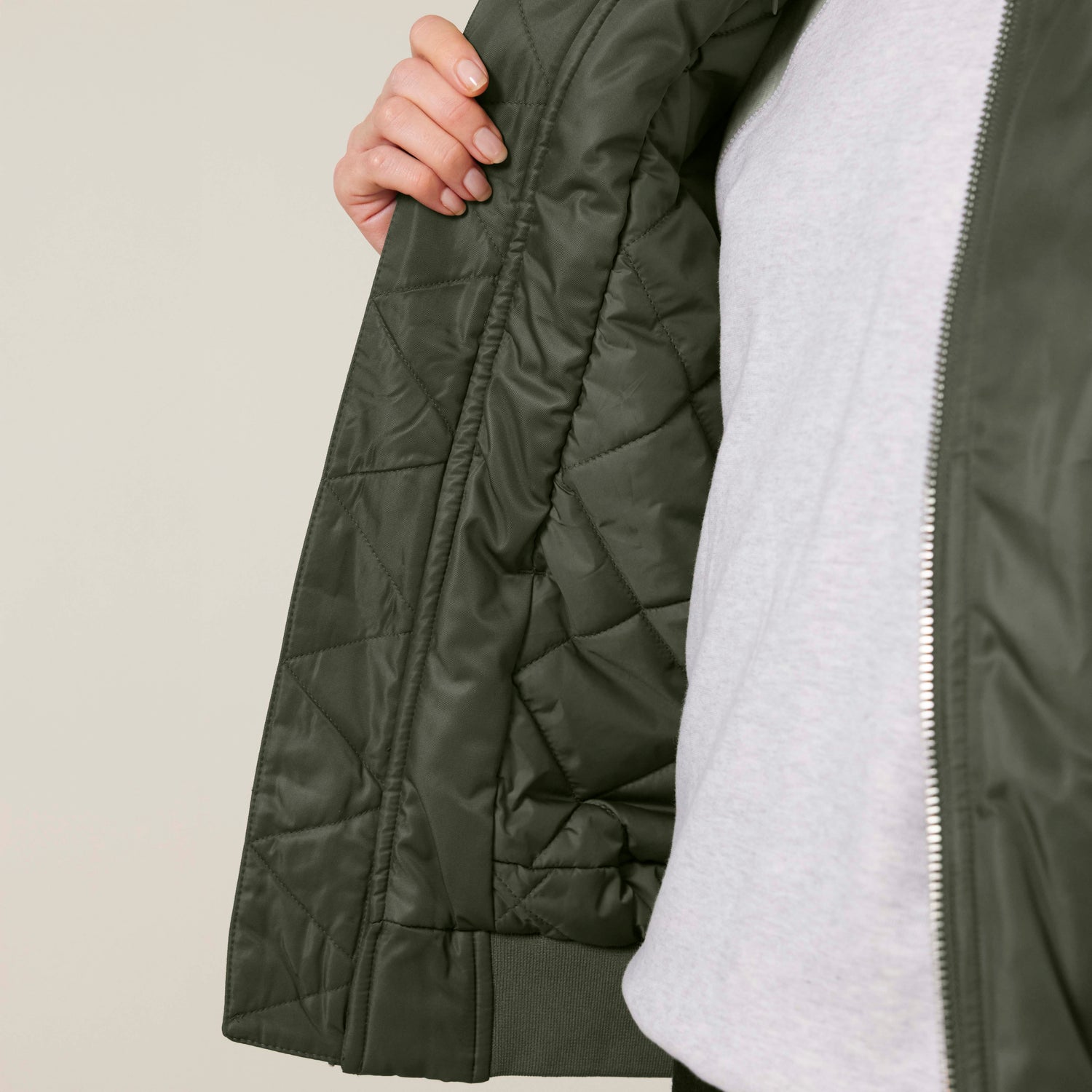 Nahaufnahme einer grünen NEW WORLD GUARDIANS GUARDIAN Bomberjacke aus 100 % recyceltem Polyester, nachhaltige Unisex-Mode in 3 Farben