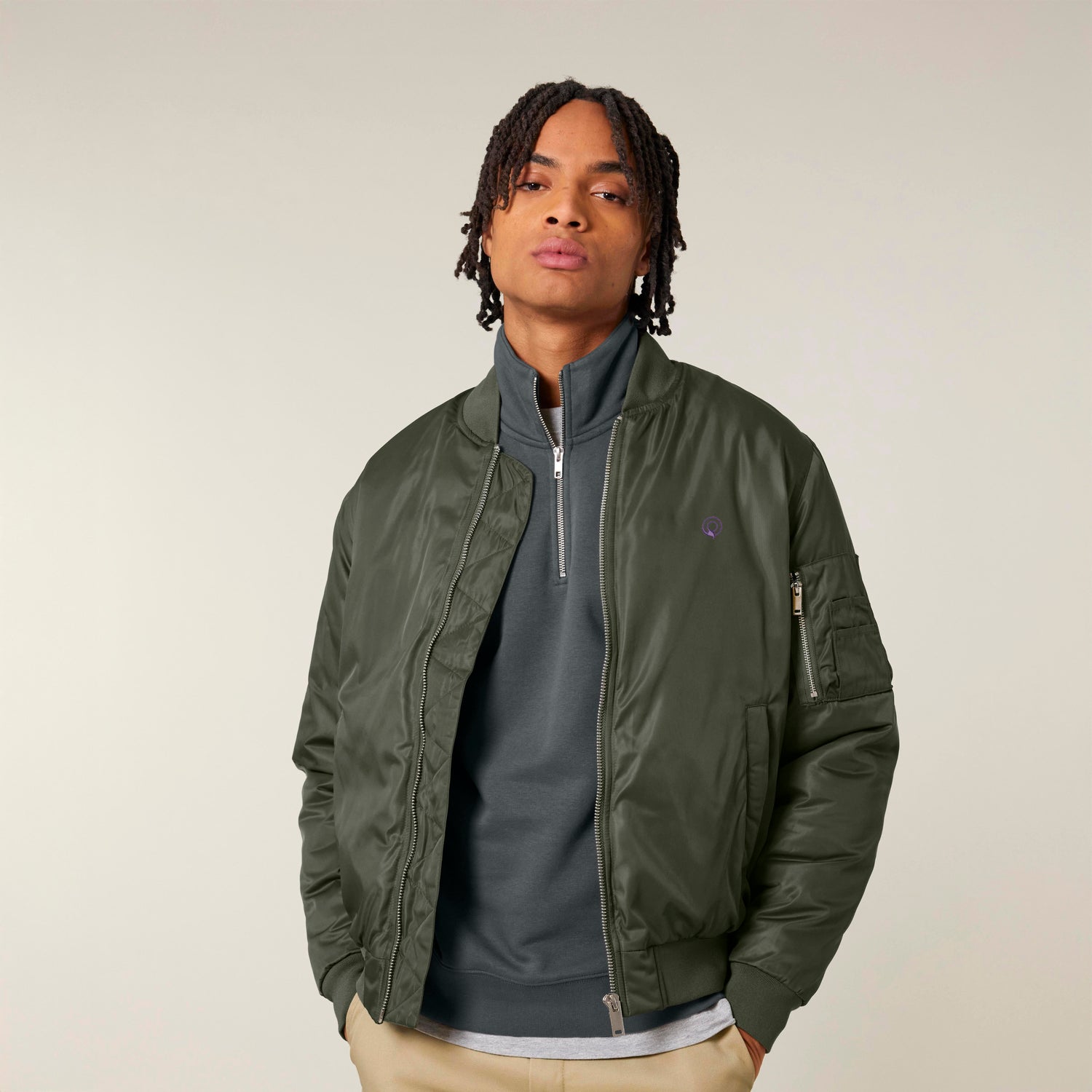Model wearing an ethical fashion Guardian bomber jacket crafted from 100% recycled polyester in green, eco-conscious unisex style, 3 colors available