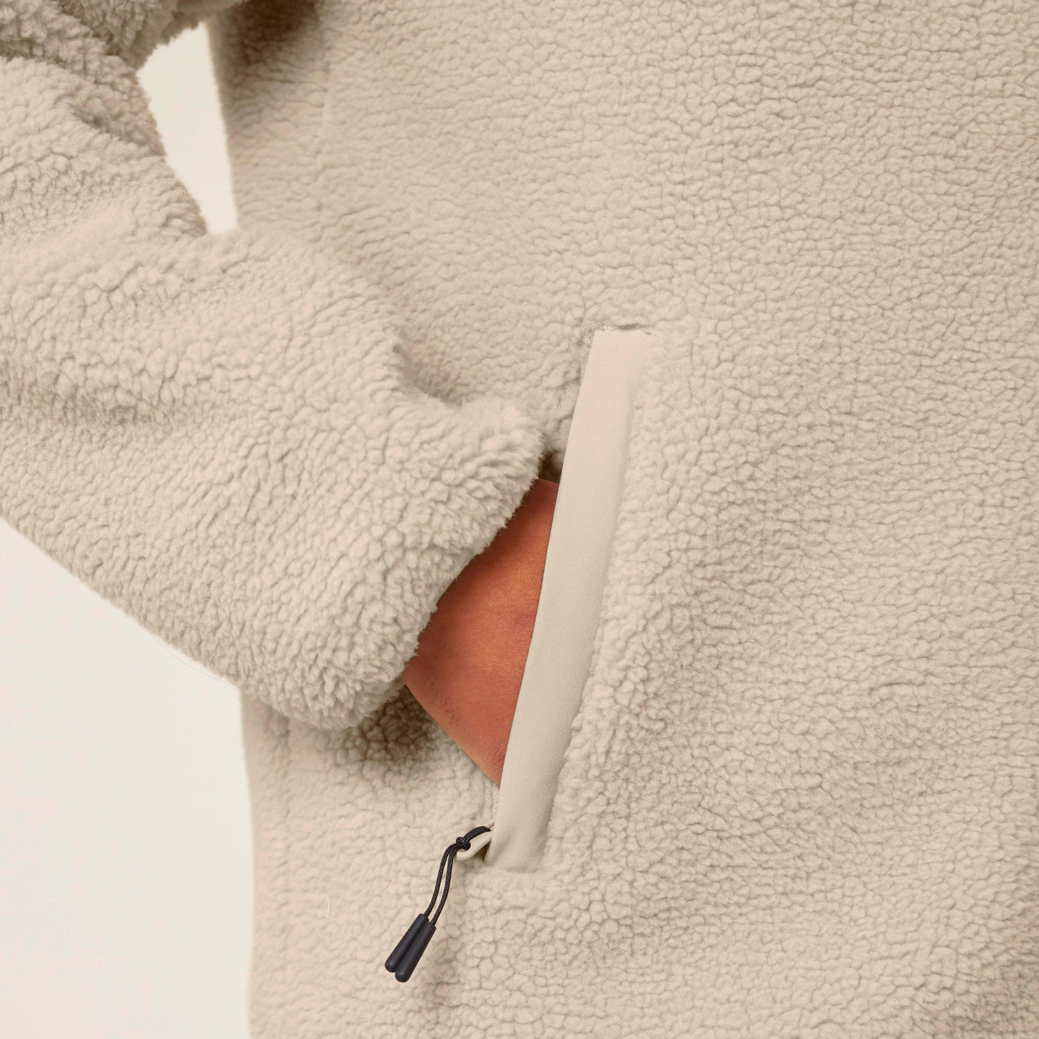 Nahaufnahme einer NEW WORLD GUARDIANS EARTH Sherpa Jacke aus 100 % recyceltem Polyester in Beige, nachhaltige Unisex-Mode in 3 Farben