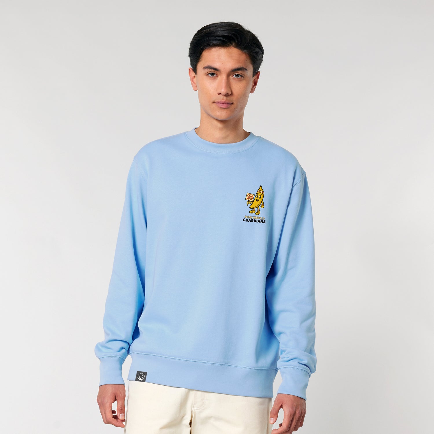 Male model wearing a Blue Soul NEW WORLD GUARDIANS unisex vegan sweater featuring Bany the banana in a comic-style front print and the full Roots for Our Future veggie squad with “Eat Us Not Them” slogan on the back. Made from 100% organic cotton. Playful vegan fashion and sustainable streetwear with character.