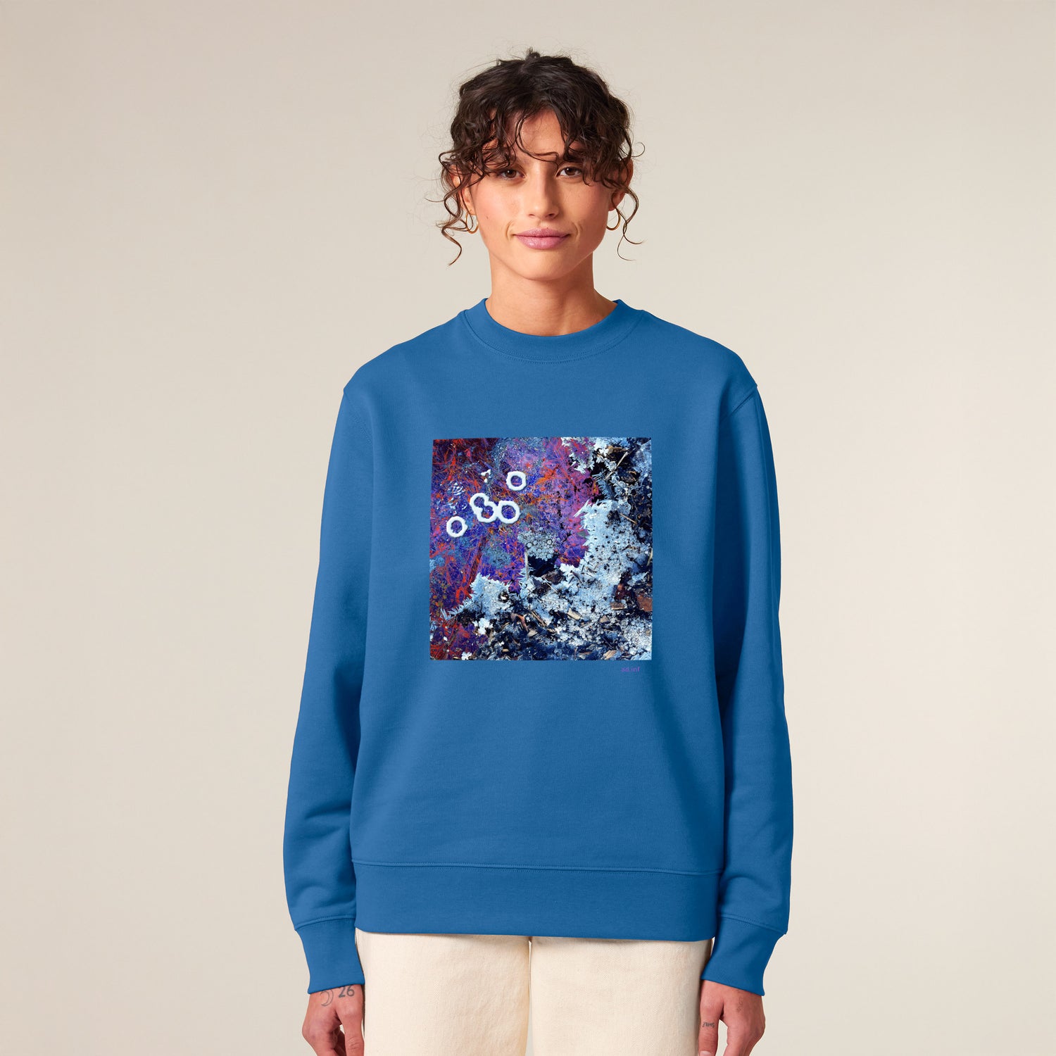 Female model wearing a bright blue sweater with a blue art print, made from 100% organic cotton – sustainable and ethically made fashion by New World Guardians.