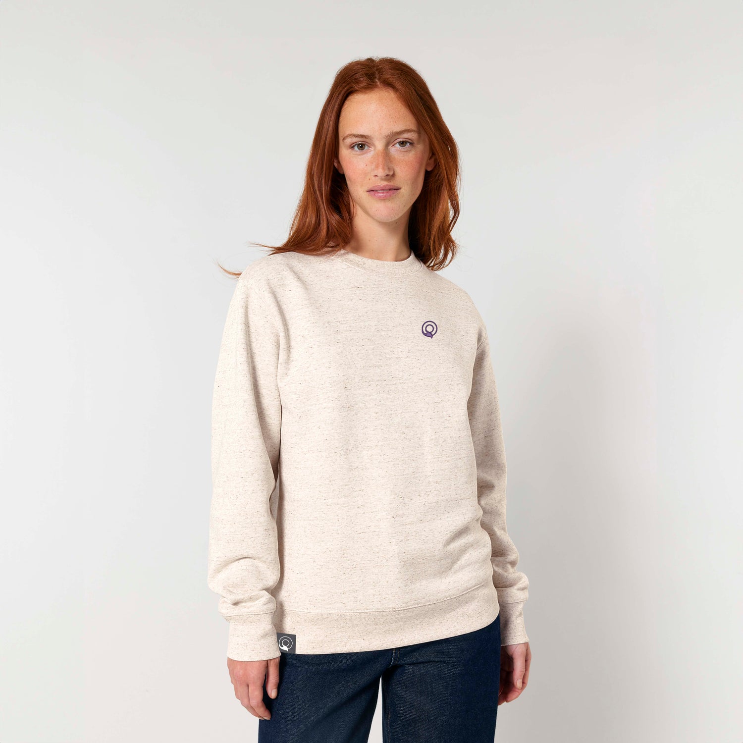 Model wears beige sustainable sweater in organic cotton with relaxed fit, NEW WORLD GUARDIANS IMPACT design, 20 color options