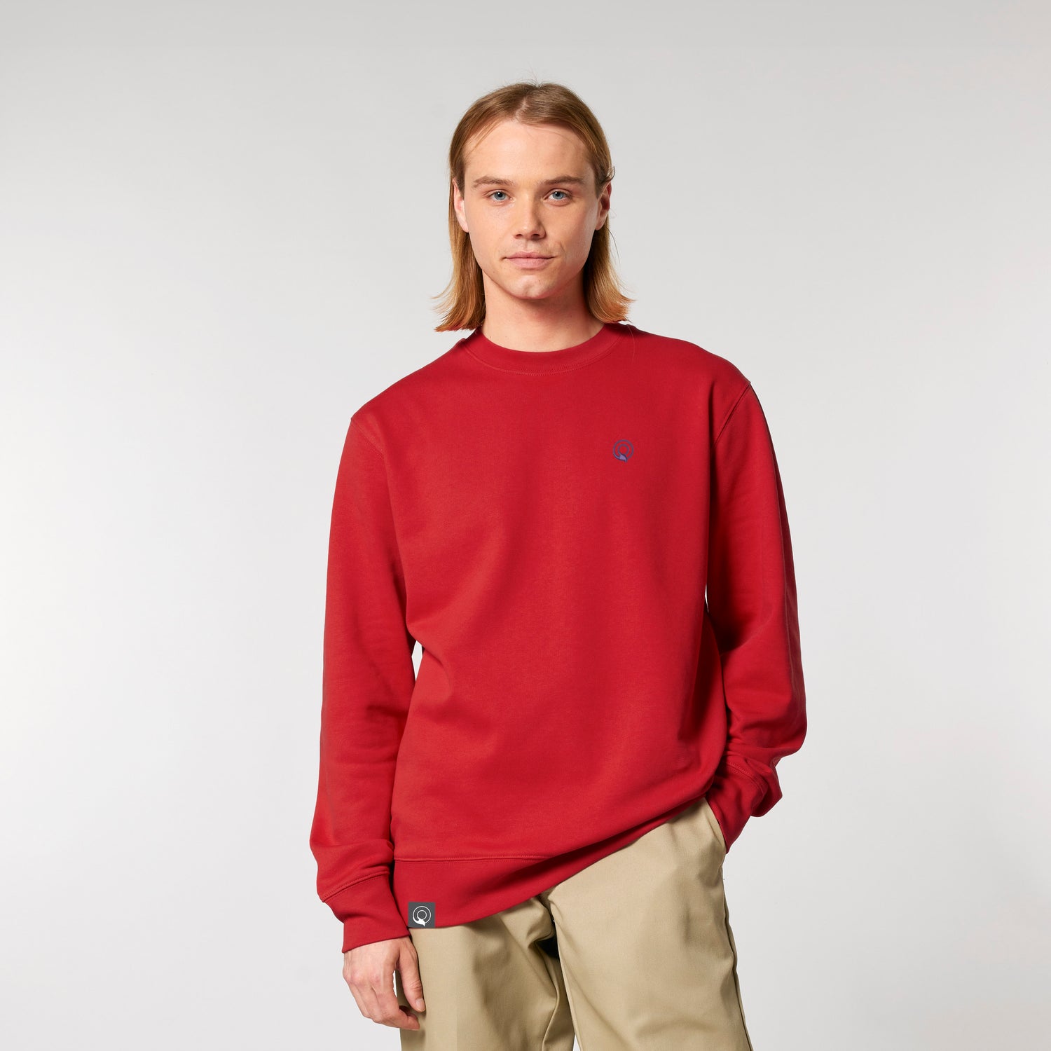 Model trägt roten NEW WORLD GUARDIANS IMPACT Sweater aus 100 % Bio-Baumwolle, nachhaltiger Unisex Pullover in 20 Farben
