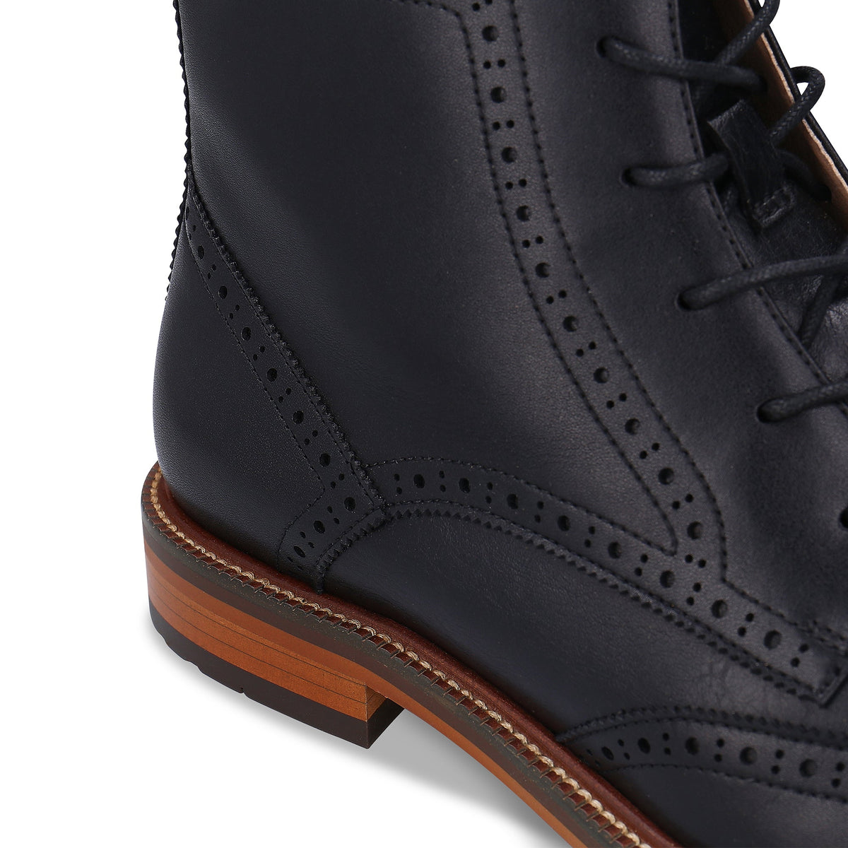 Brogue-Schuh aus schwarzem Leder mit brauner Sohle auf weißem Hintergrund