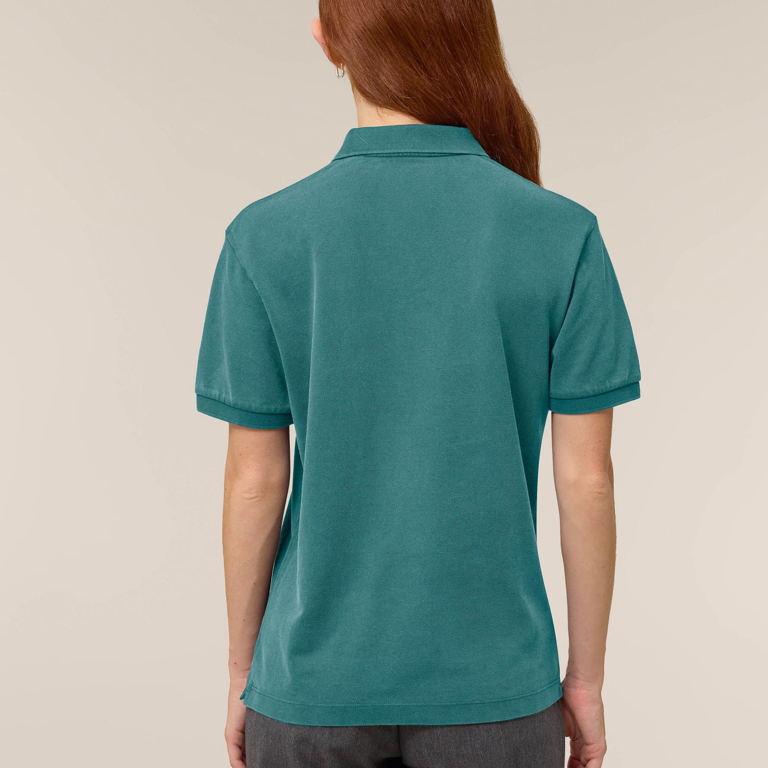 Back view of the garment-dyed hydro blue unisex polo t-shirt worn by a female model – sustainable and ethically made fashion by New World Guardians.