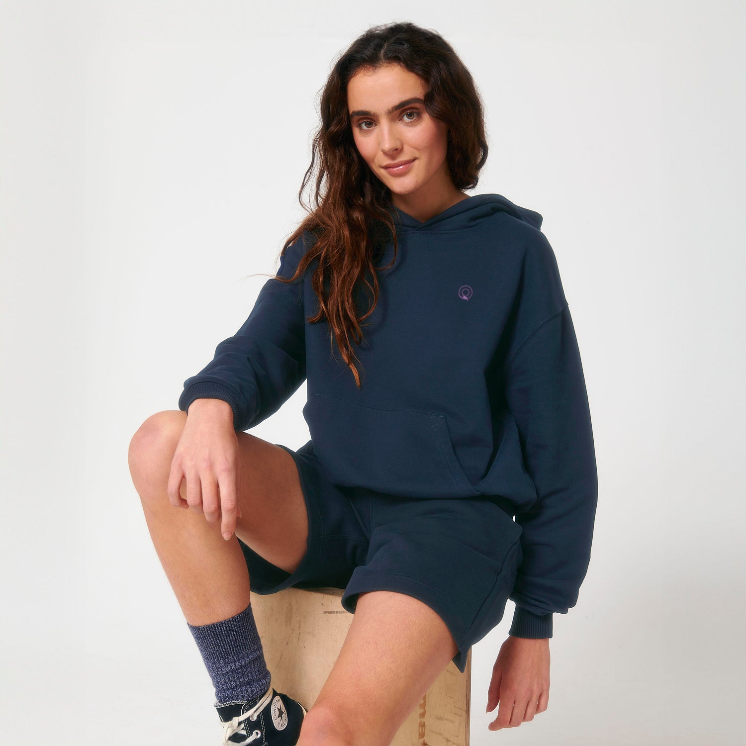 Model wears soft and durable unisex hoodie with clean design and ethical materials, eco-friendly organic cotton, 11 colors