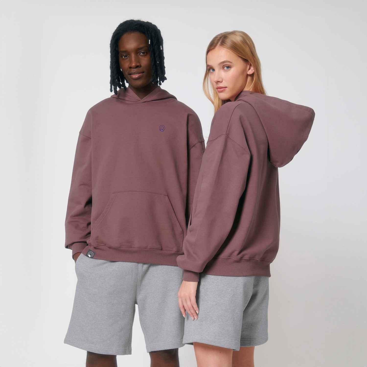 Two models wear sustainable hoodies with premium stitching and double-layer hood, eco-friendly unisex design, 11 color options