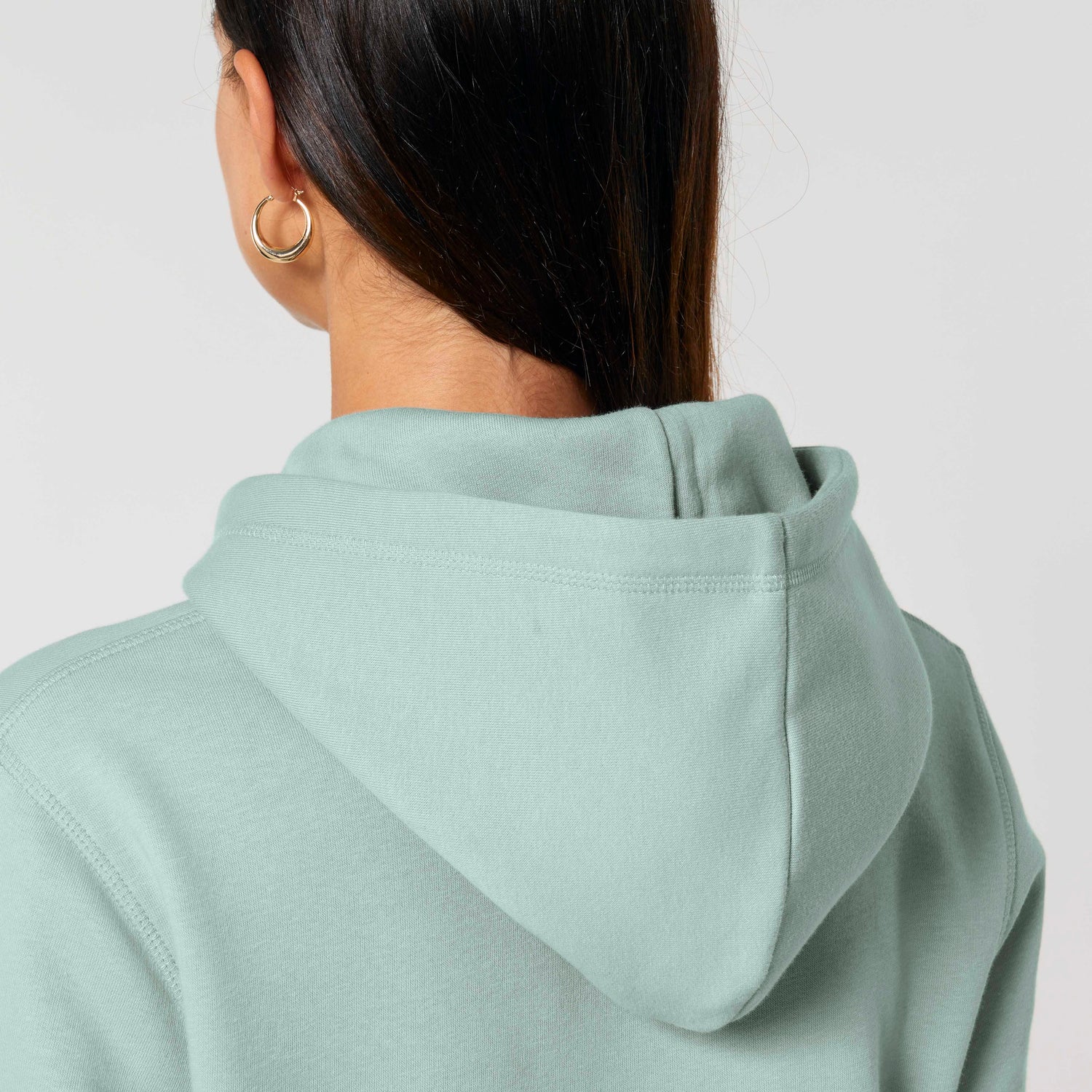 Detail of minimalist unisex hoodie from NEW WORLD GUARDIANS EARTH line, eco-friendly and vegan, available in 16 colors