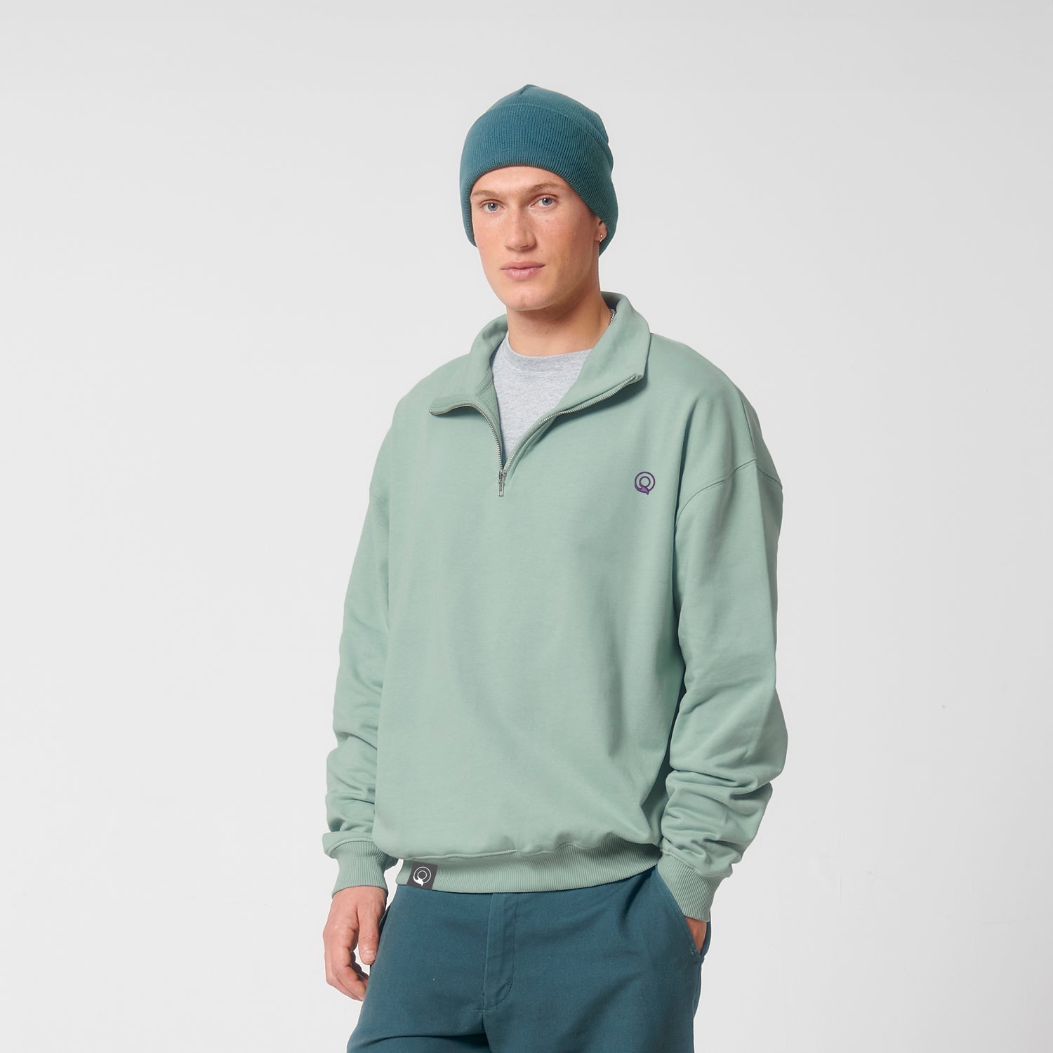 Model trägt NEW WORLD GUARDIANS CONSCIOUS Sweater aus 100 % Bio-Baumwolle, nachhaltiger Unisex Quarter-Zip Pullover in 6 Farbvarianten