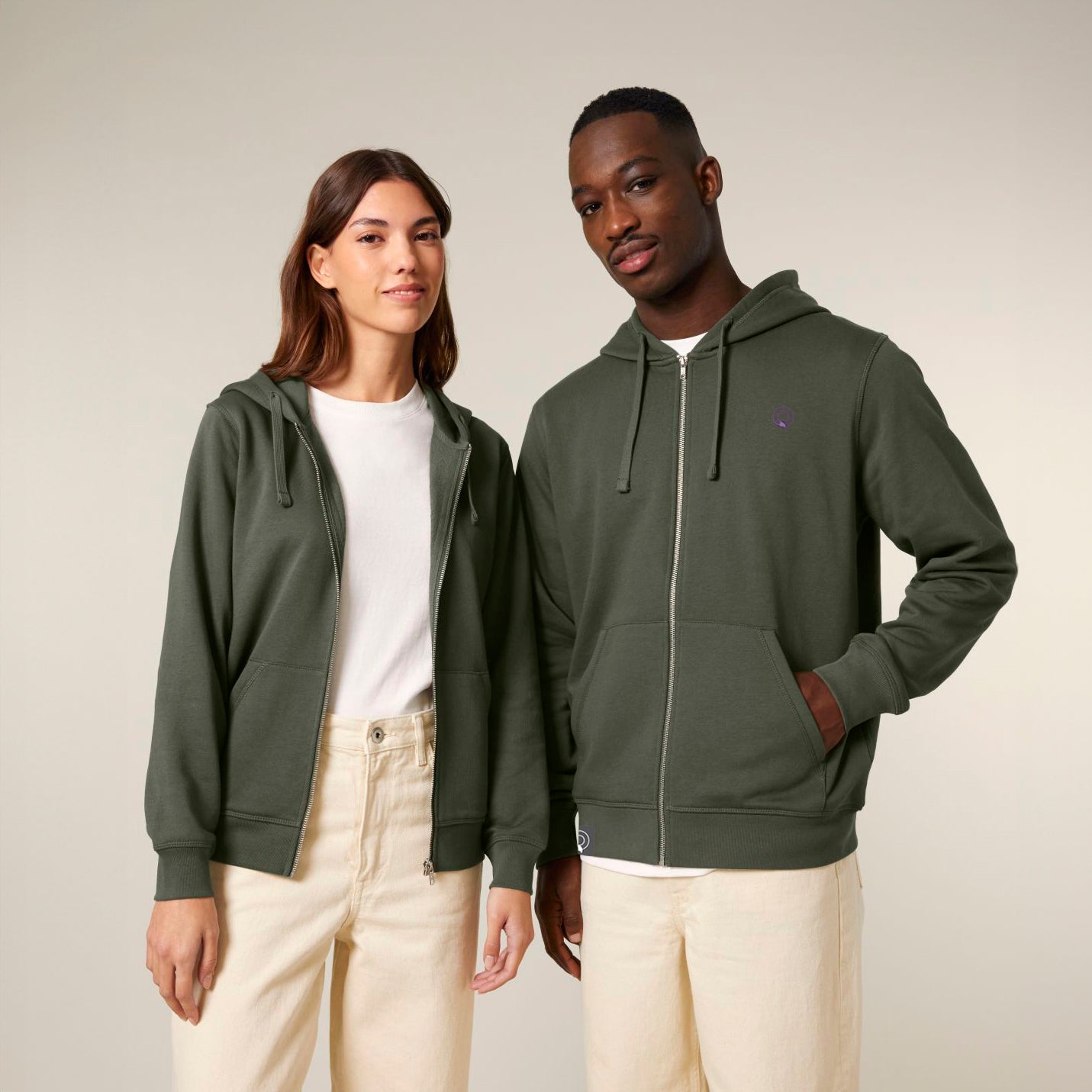 Two models wearing green sustainable hoodies with zip front, ribbed cuffs and flatlock seams, NEW WORLD GUARDIANS EARTH design, 12 colors