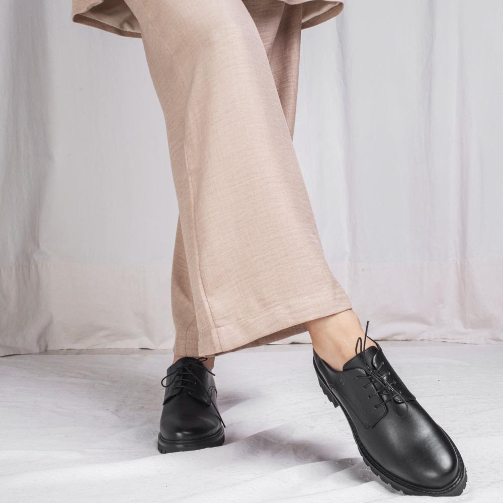 crossed foot wearing flat derby shoes with pants | NAE Vegan Shoes