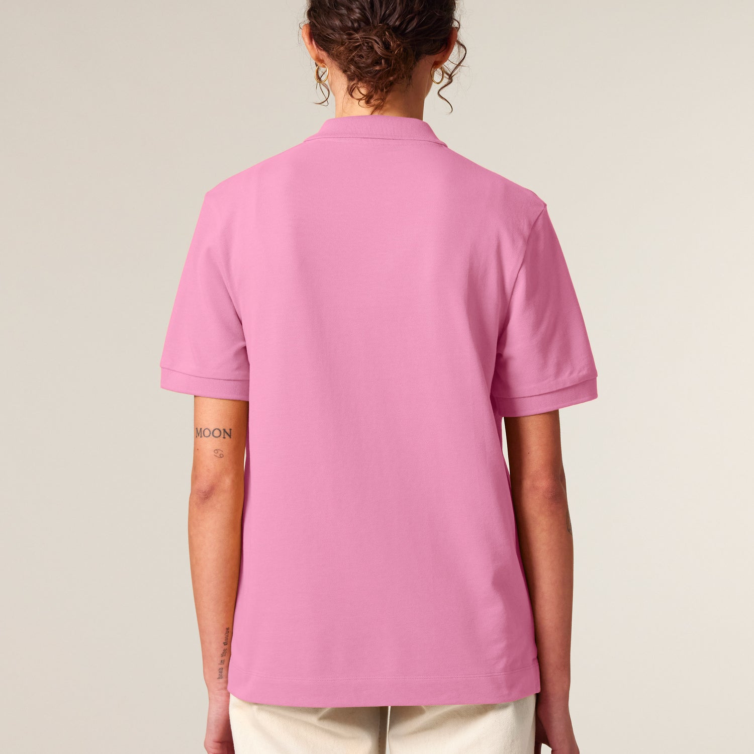 Back View, Female model wearing pink unisex polo shirt – sustainable and ethically made fashion by New World Guardians.