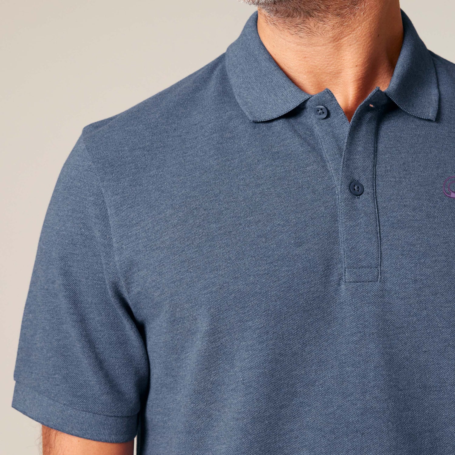 Close-Up, Male model wearing an dark heather blue unisex polo shirt – sustainable and ethically made fashion by New World Guardians.