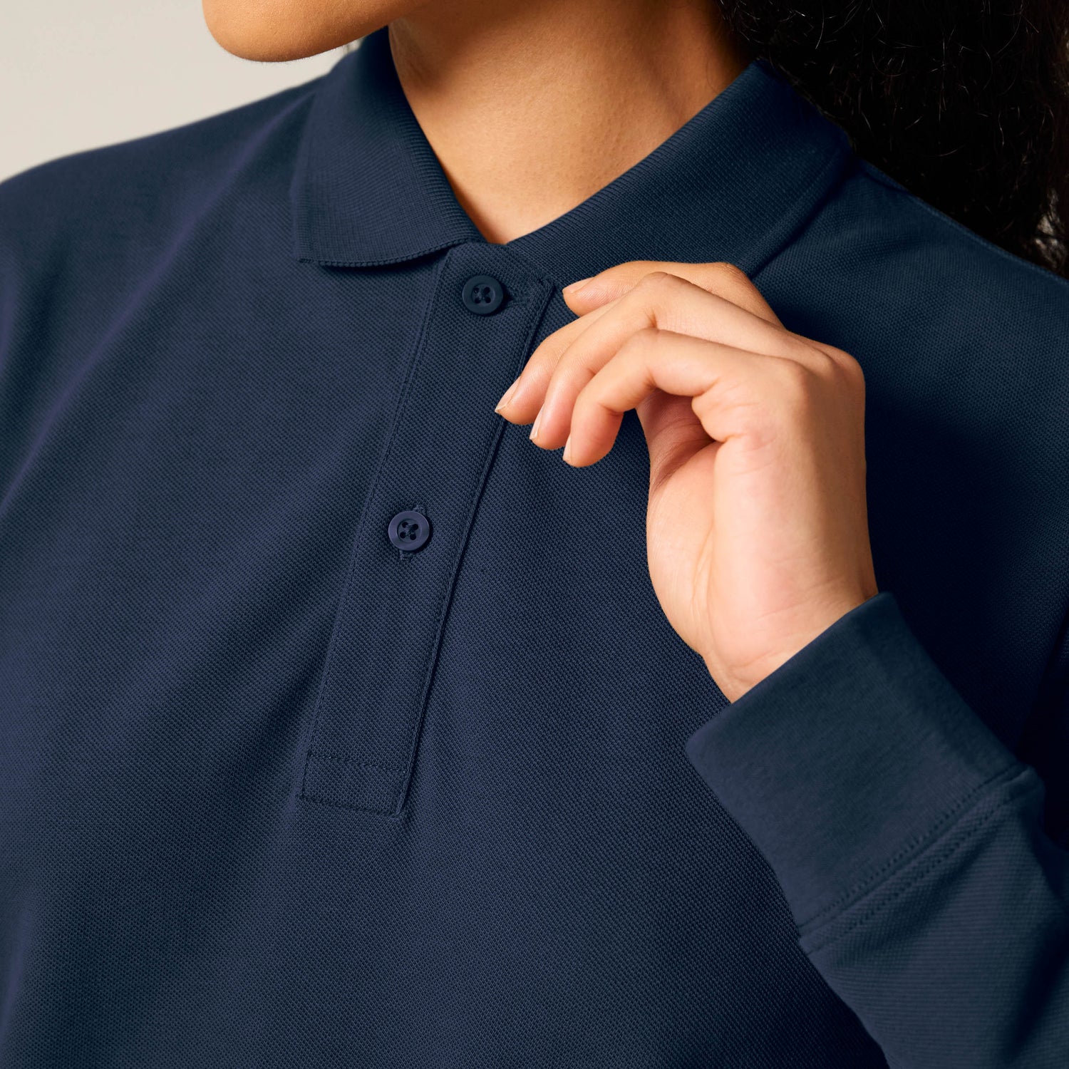 Female model wearing a black long sleeve unisex polo shirt – sustainable and ethically made fashion by New World Guardians.