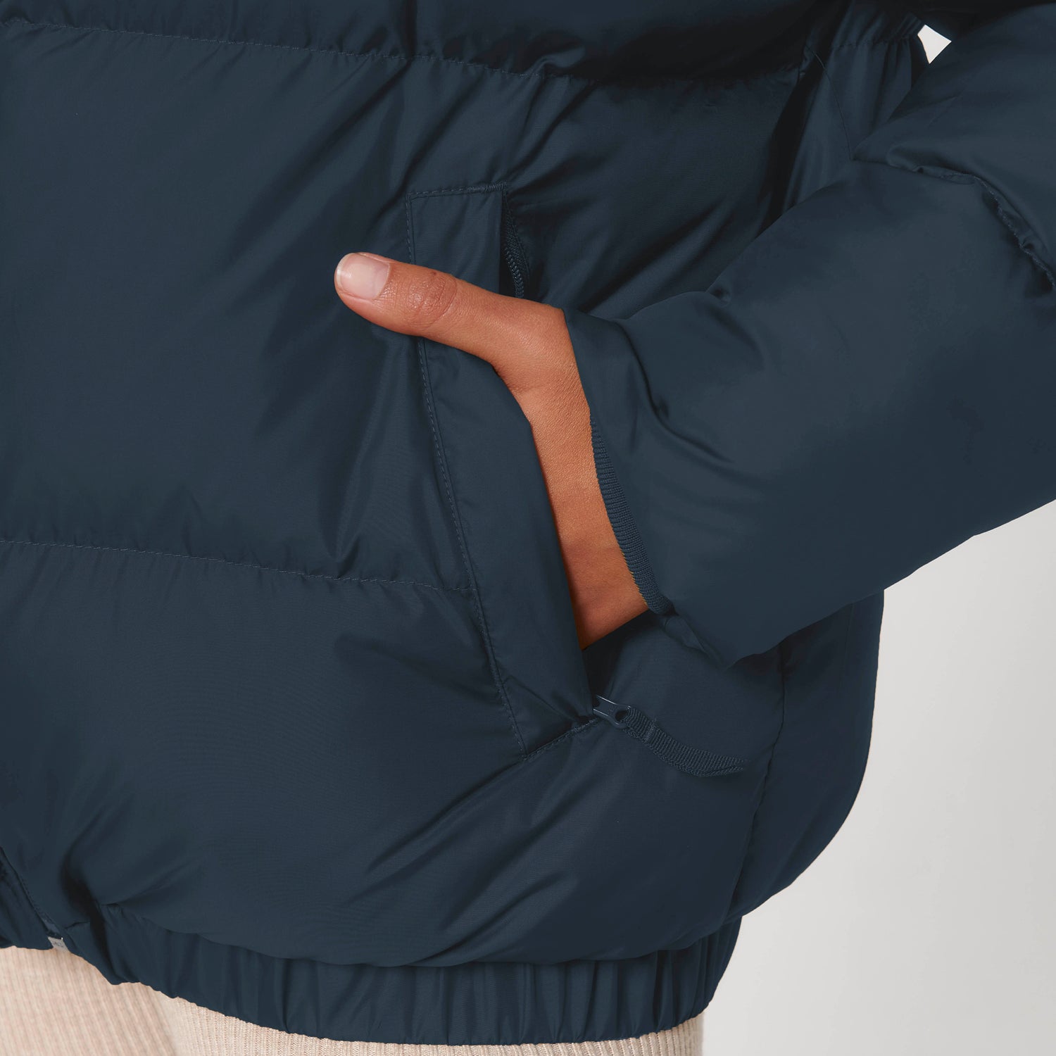 Detail of eco-friendly unisex puffer jacket with durable construction and adjustable hem, 100% recycled polyester, 4 colors