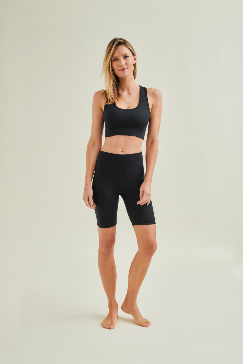 Woman wearing circular design black yoga shorts and black yoga bra by Wellicious styled for Pilates and fitness in breathable, non-toxic fabric