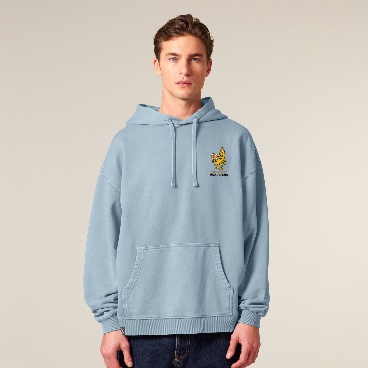 Male model wearing a blue NEW WORLD GUARDIANS unisex vegan hoodie featuring Bany the banana in a comic-style front print and full veggie squad design on the back. From the Roots for Our Future collection. Made with 100% organic cotton. Bold vegan fashion and sustainable streetwear for changemakers.