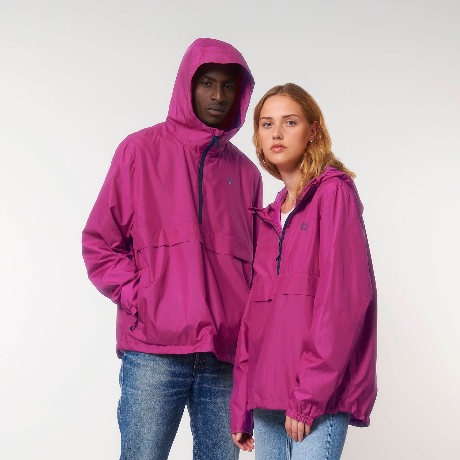 Two models wearing pink vegan and cruelty-free anorak jackets, eco-friendly unisex outerwear by NEW WORLD GUARDIANS, 8 color options