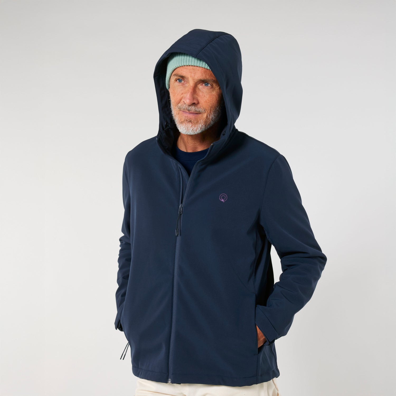 Man wears navy blue Adventure-ready softshell jacket made from recycled polyester with fleece lining, sustainable outerwear