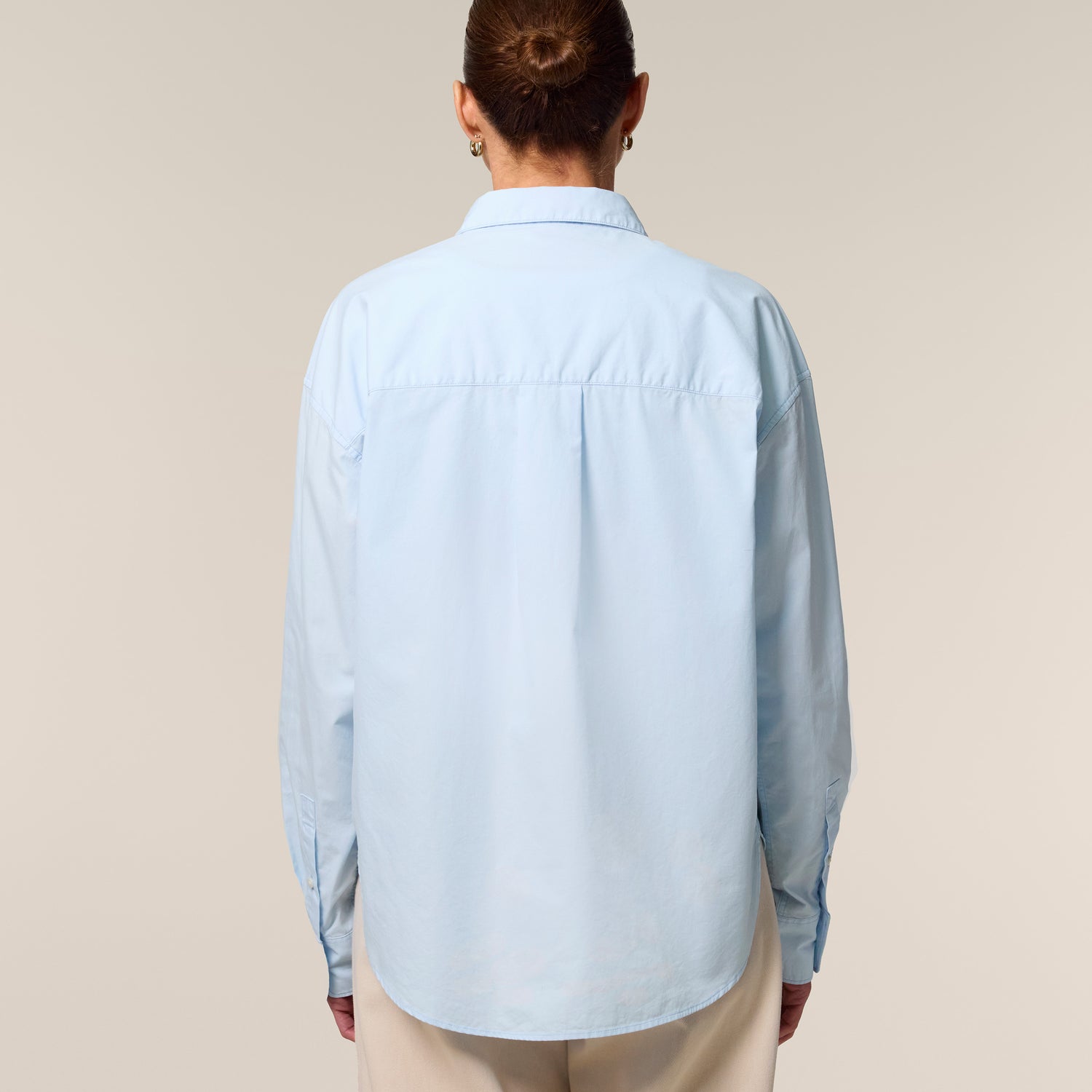 Female model wearing a summer blue shirt – sustainable and ethically made fashion by New World Guardians.