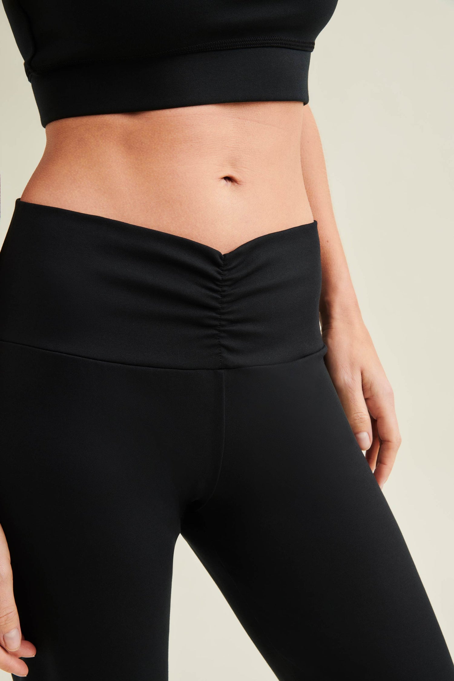 Female model wearing non-toxic black movement trousers by Wellicious suitable for training, travel and daily wear