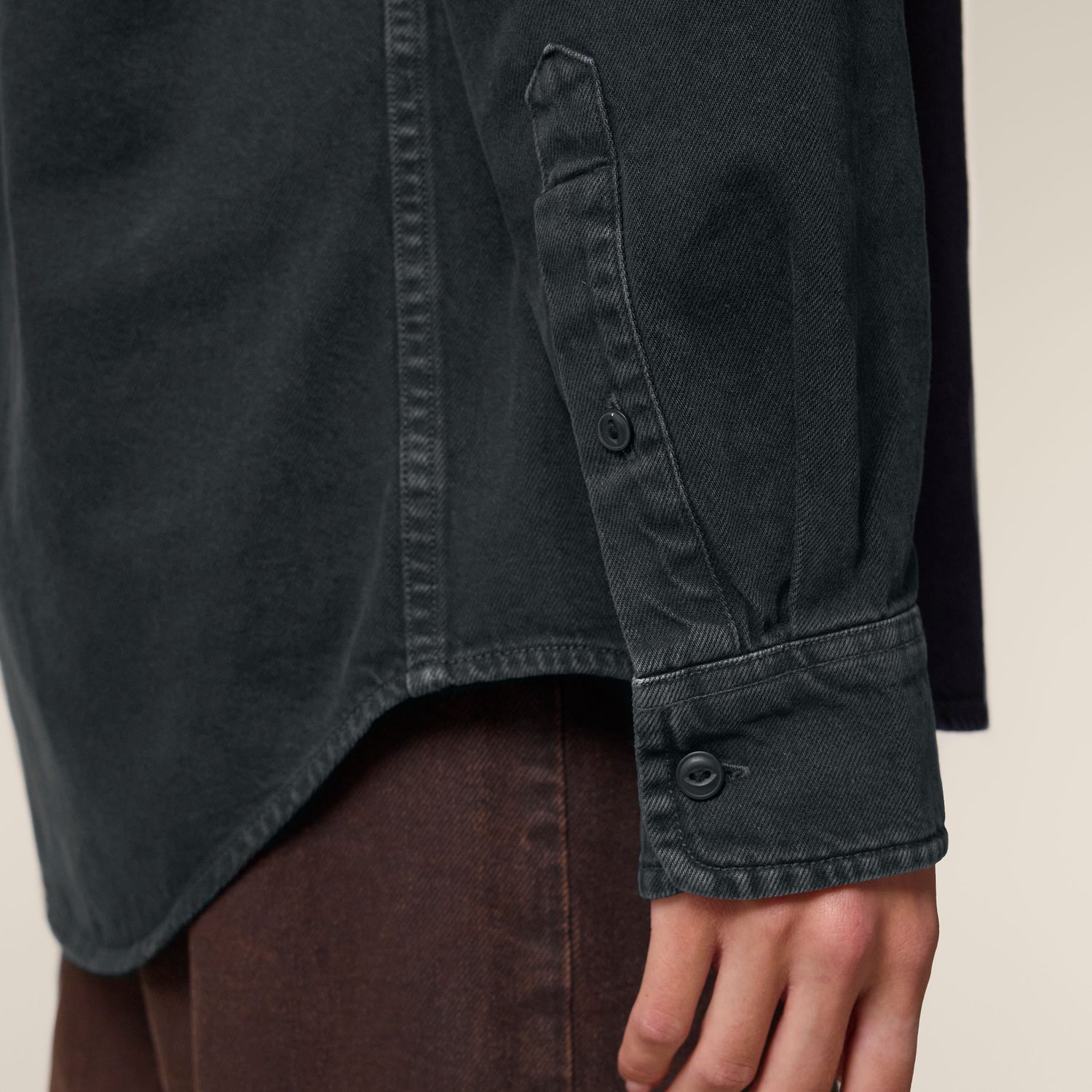 Female model wearing a garment-dyed black rock worker shirt – sustainable and ethically made fashion by New World Guardians.