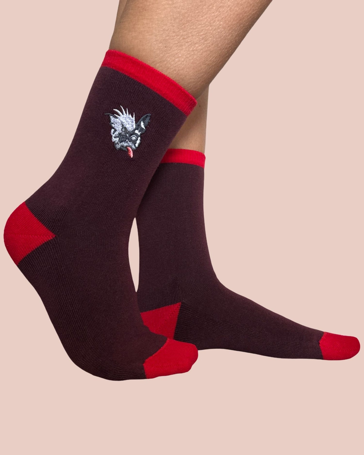 Burgundy socks with red accents and a unique dog design on a beige background
