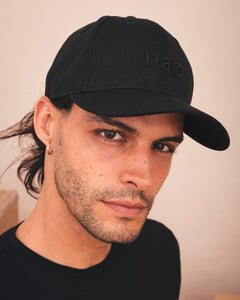 Man wearing a black cap with nae branding
