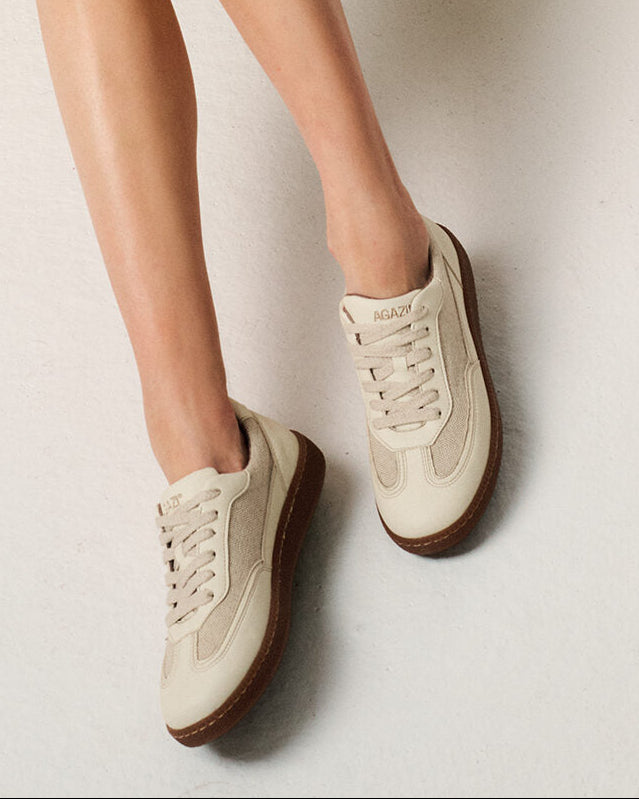 Beige vegan apple leather sneakers worn by a person