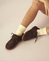 Person wearing brown barefoot shoes made from vegan leather.
