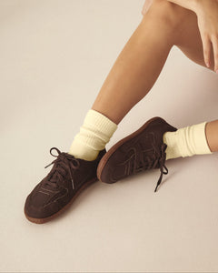 Person wearing brown barefoot shoes made from vegan leather.