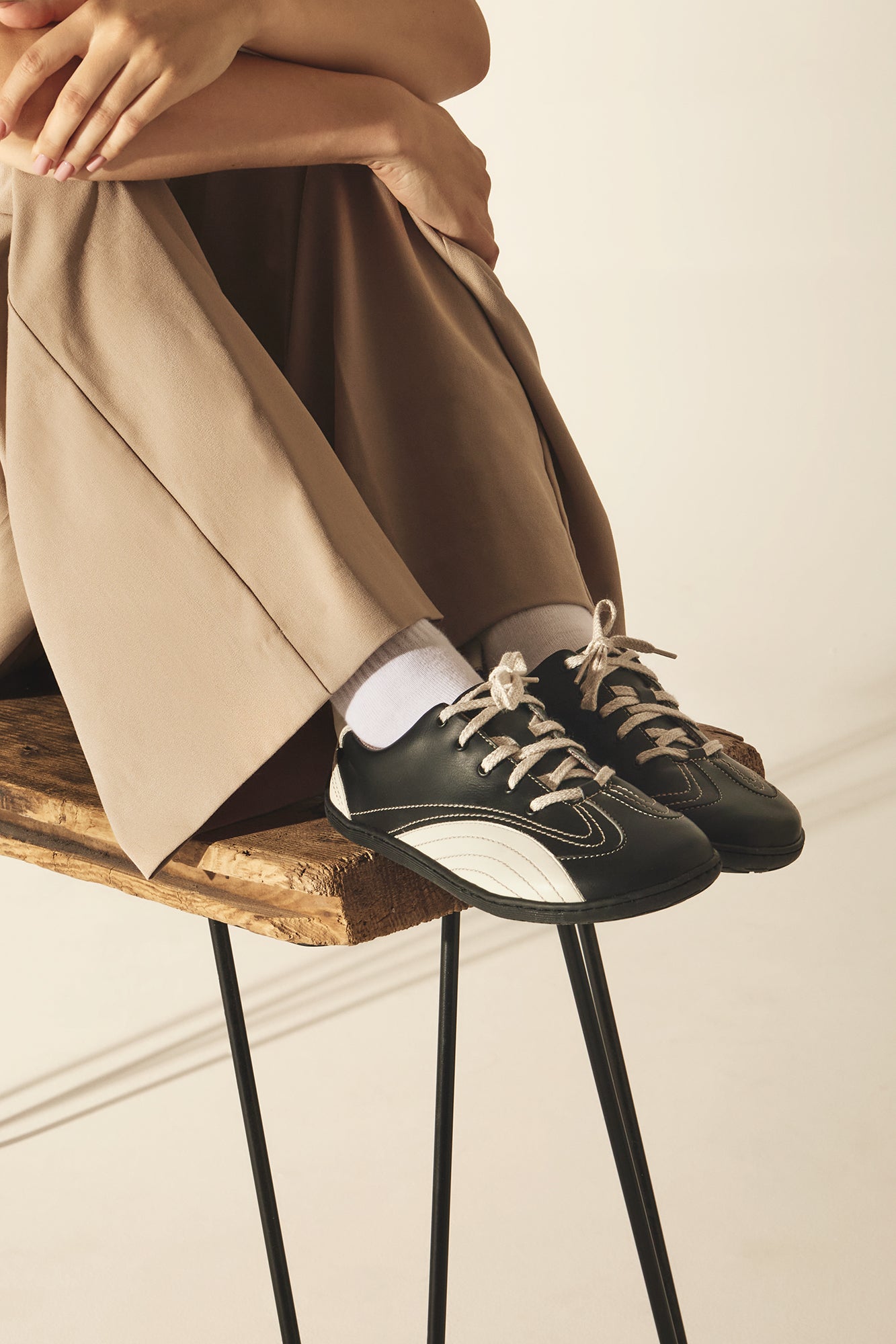Person wearing black and white barefoot shoes, sustainable and vegan.