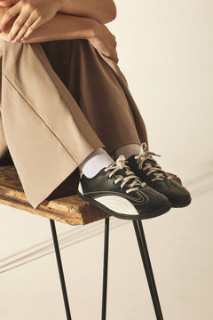 Person wearing black and white barefoot shoes, sustainable and vegan.