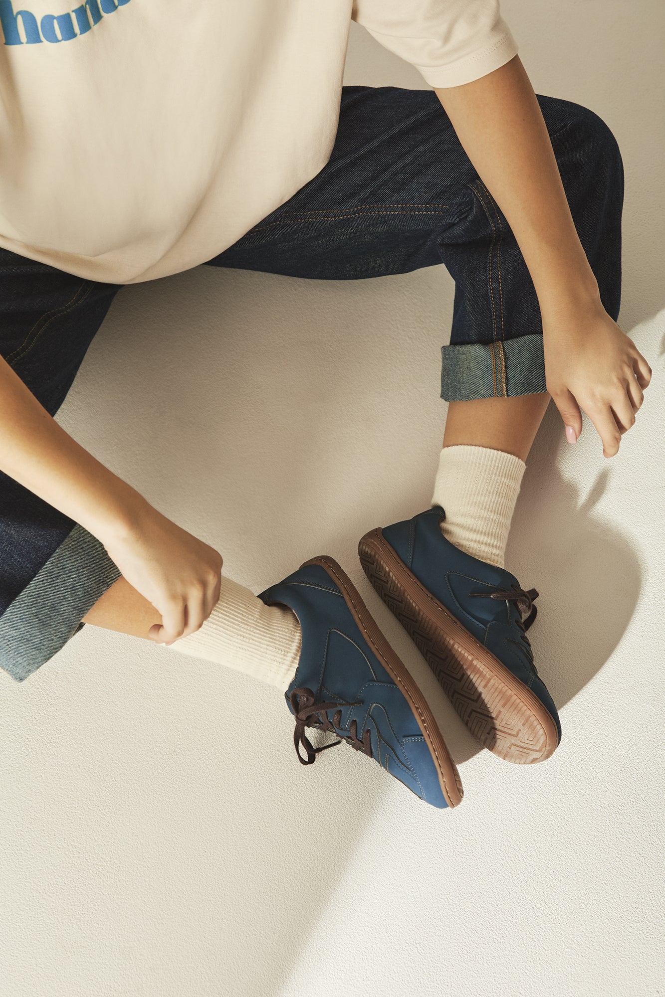 Person wearing blue sustainable barefoot shoes.