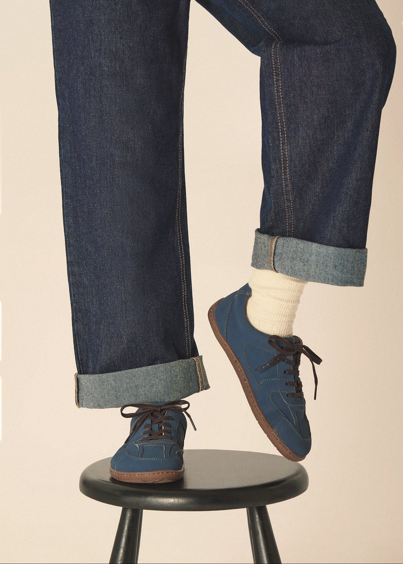 Person wearing vegan blue barefoot sneakers made from vegan leather.
