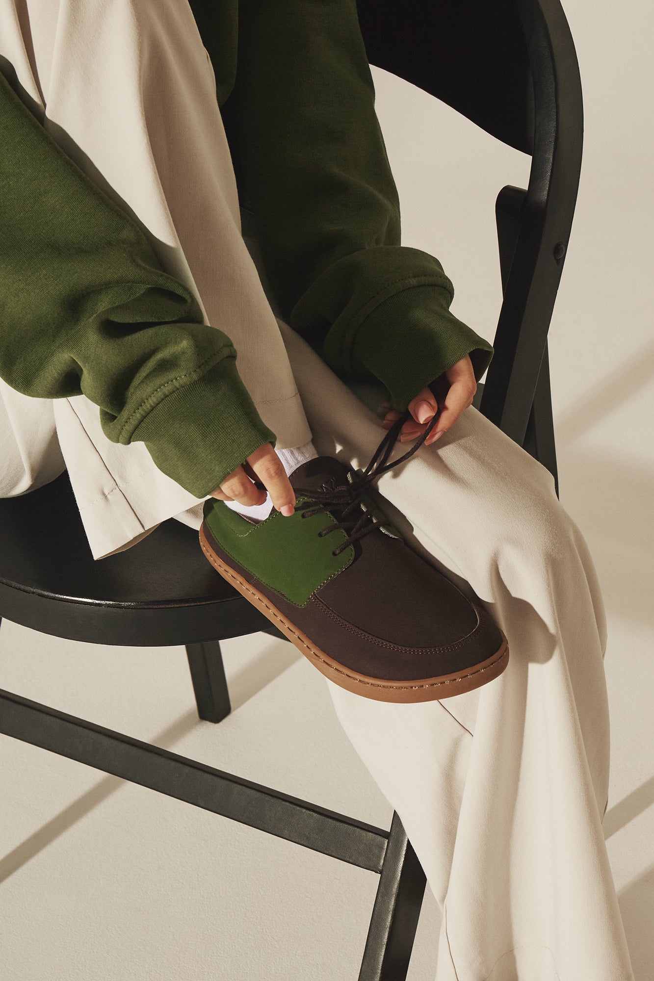 Person wearing vegan brown & green barefoot shoes for natural movement.