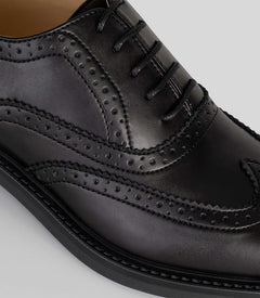 Vegan Oxford Brogue - Woman close-up showing broguing details and sleek black finish.