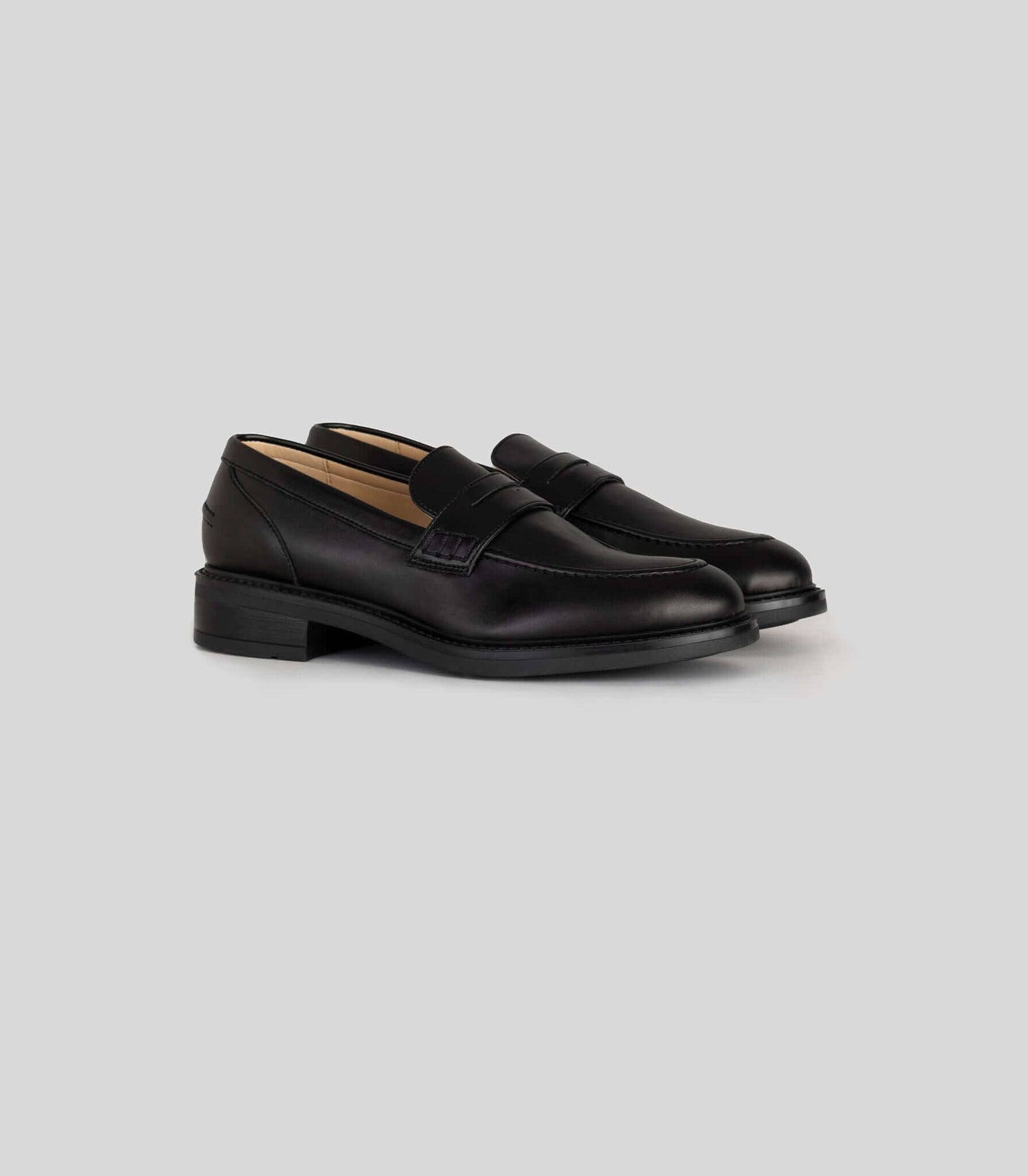 Vegan Loafer - Woman in black leather, versatile for casual and formal outfits, featuring a distinctive U-shaped pattern.