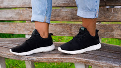 Close up of a woman wearing a pair of black and white hemp shoes by 8000 Kicks.