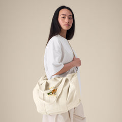 Woman Carrying Guardian Travel Bag – Vegan Recycled Cotton Duffel by NEW WORLD GUARDIANS