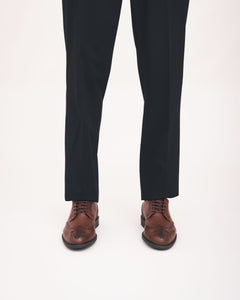 Black pants with brown dress shoes on a white background