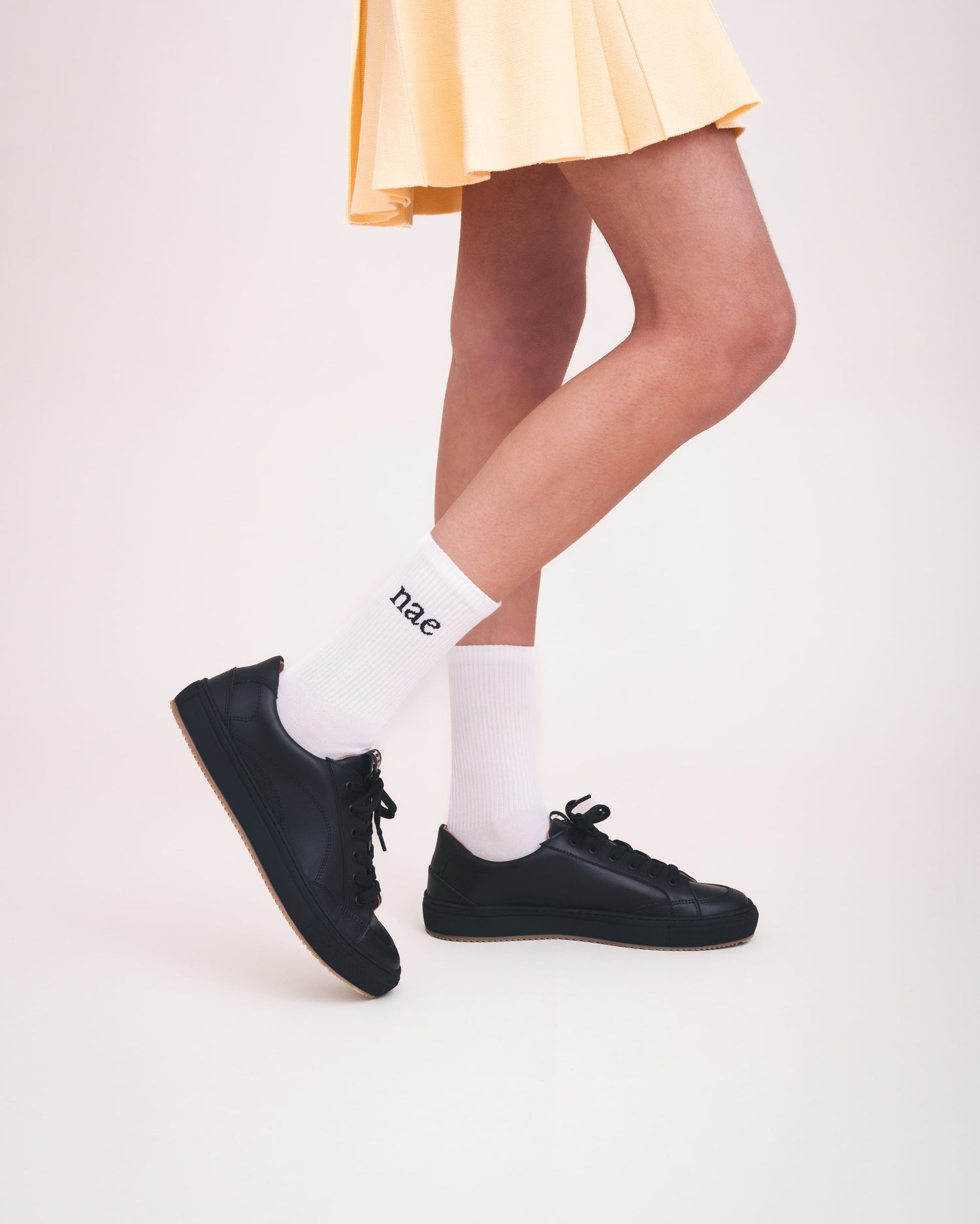 NAE Vegan Shoes black sneakers urban style low-top lace-up with skirt and socks