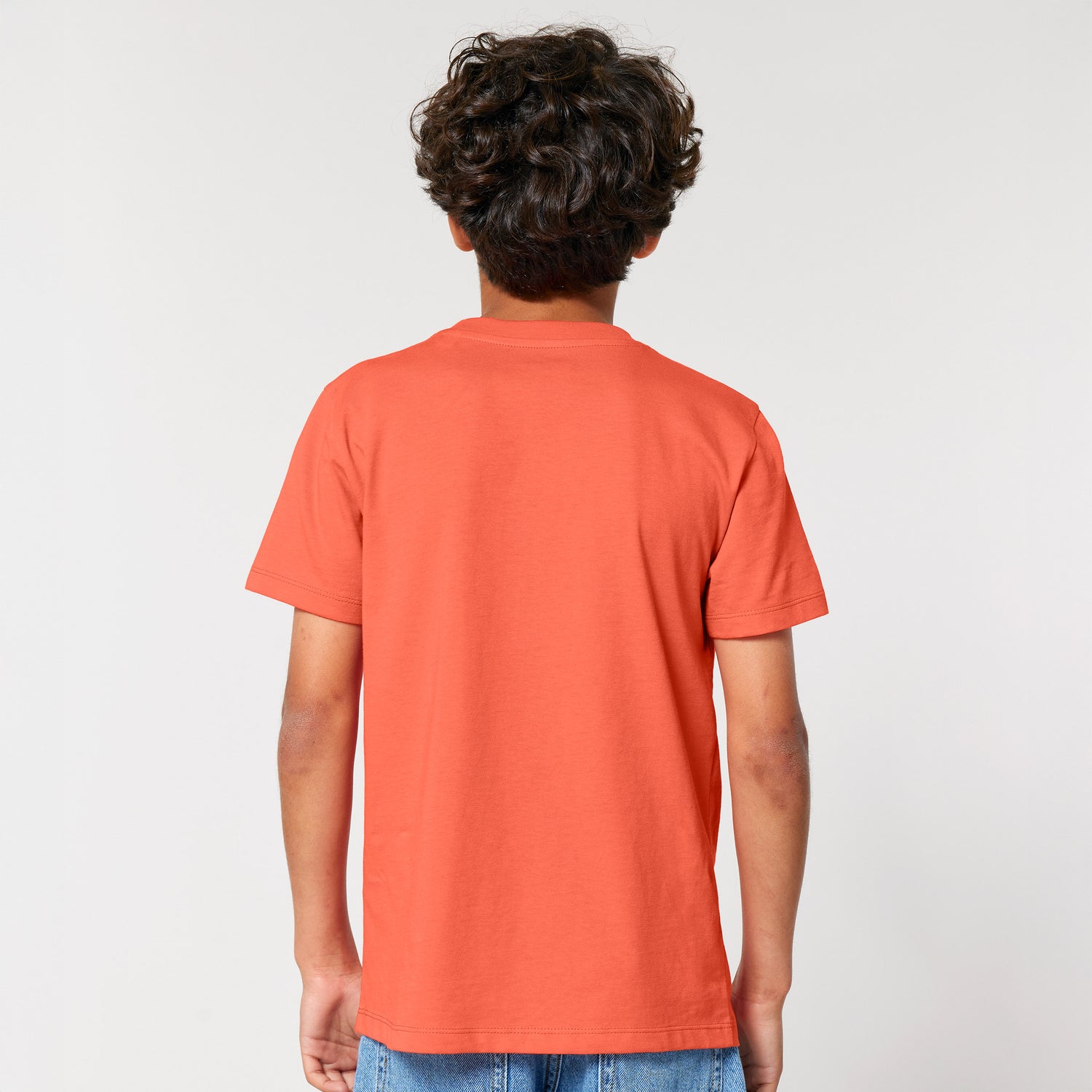 Eco-friendly children’s t-shirt in orange organic cotton, back view, modeled by kid