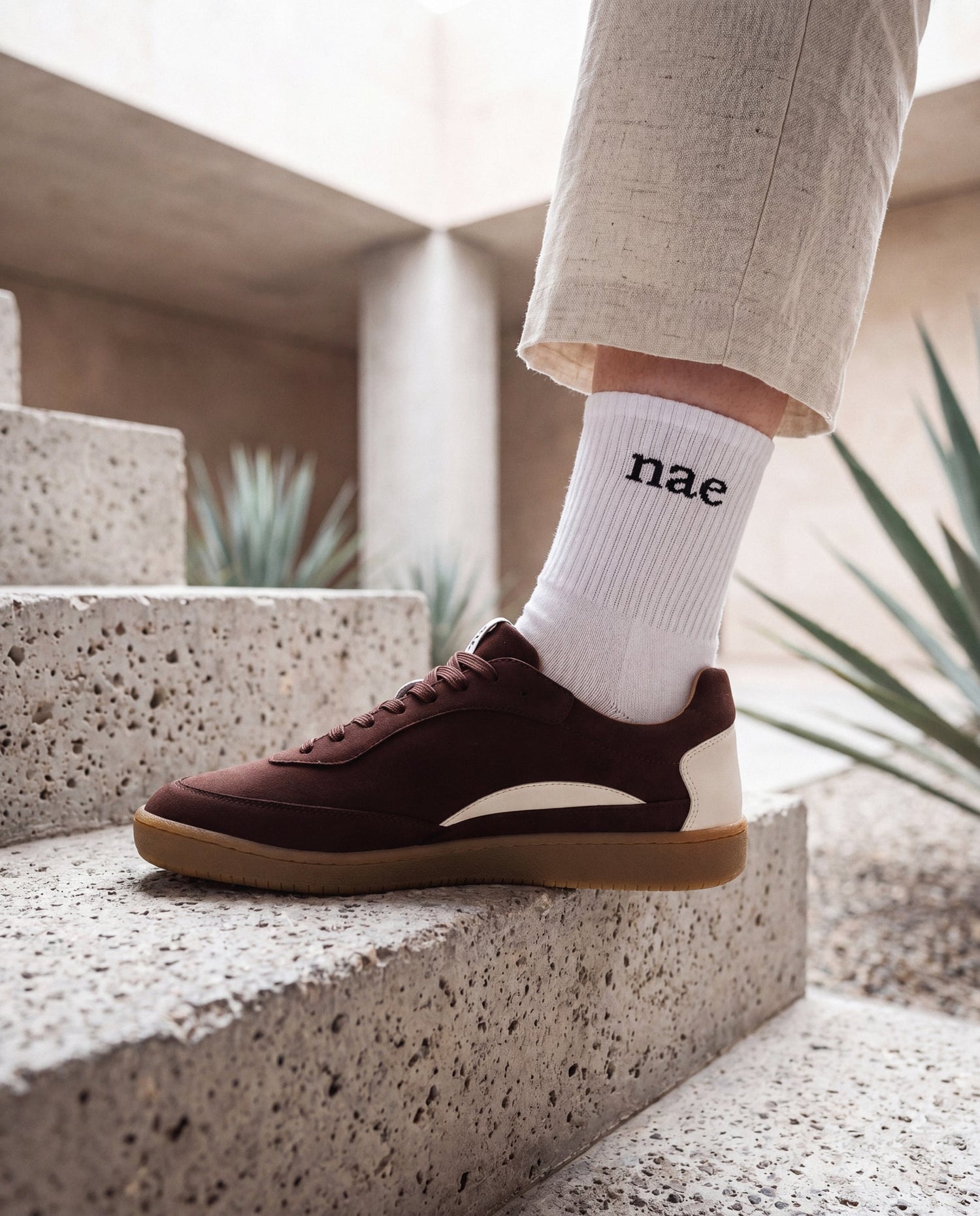 MACKAY Beige vegan sneaker worn by woman on concrete stairs — unisex retro sneaker made in Portugal