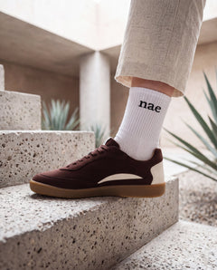MACKAY Beige vegan sneaker worn by woman on concrete stairs — unisex retro sneaker made in Portugal
