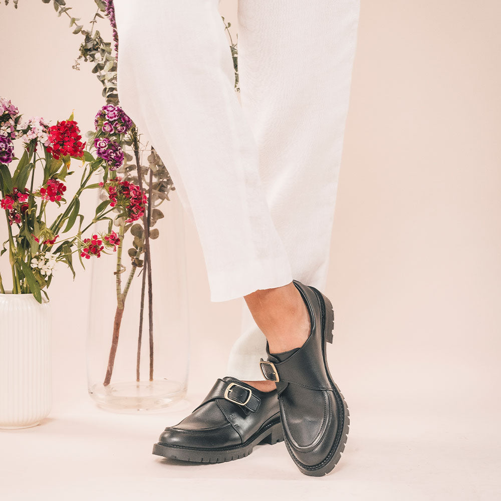black vegan loafers wearing white pants crossed foots | NAE Vegan Shoes