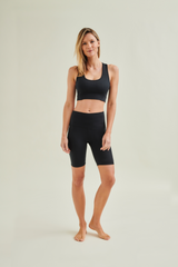 Woman wearing circular design black yoga shorts and black yoga bra by Wellicious styled for Pilates and fitness in breathable, non-toxic fabric 