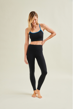 Woman wearing a black sports bra and high-waisted circular leggings by Wellicious, showcasing toxin-free and microplastic-free fabric