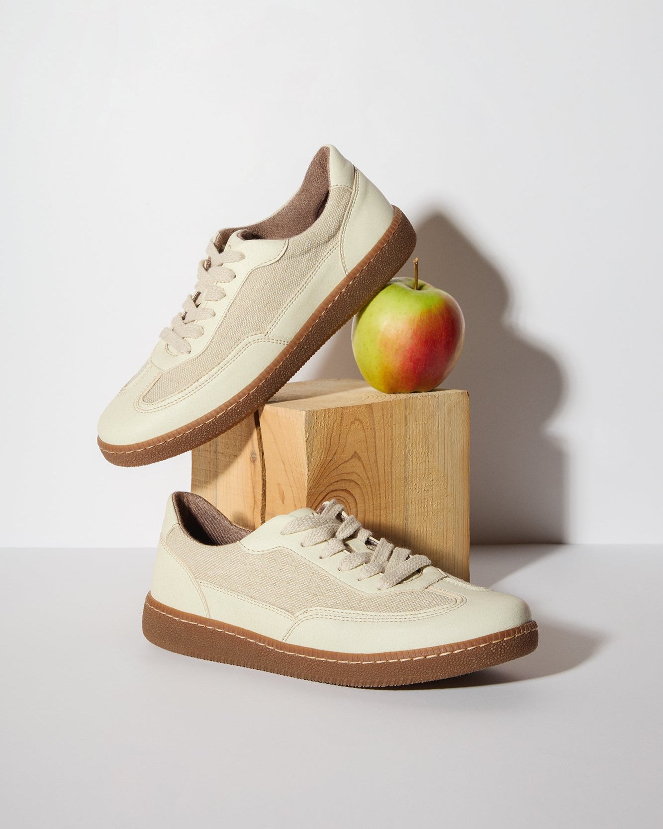 Pair of beige vegan leather and linen sneakers with brown soles